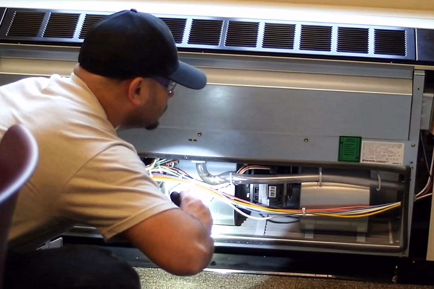 Trades person examining HVAC unit